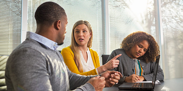 Three people in office discussing