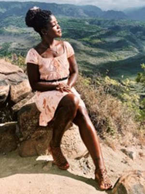 female sitting on a rock looking out over the scenery