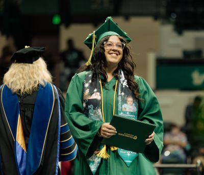 Rasmussen University graduate receiving diploma at commencement ceremony