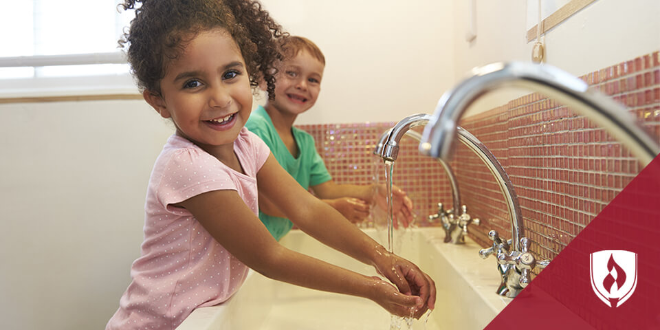 two girls washing their hands