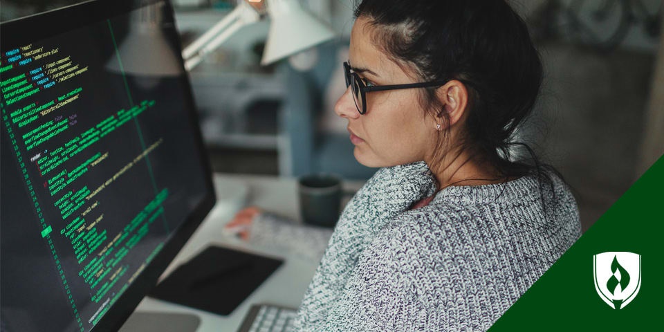 female developer reading code on a monitor representing everything you need to know about becoming a web developer