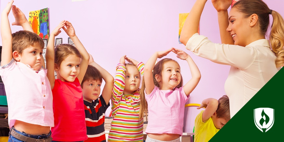 photo of female teacher playing with young children