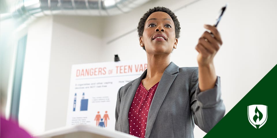 Woman in blazer at podium giving a presentation about teen vaping.