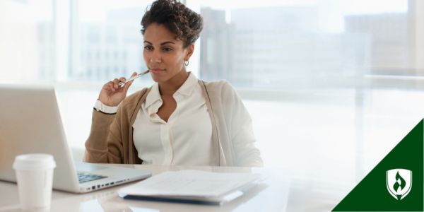 A business professional sits at her desk with a pencil and computer