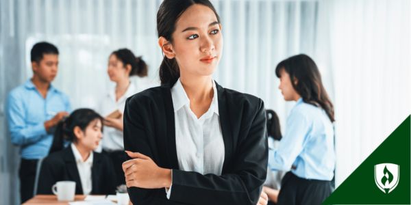 A finance professional stands in front of a busy office