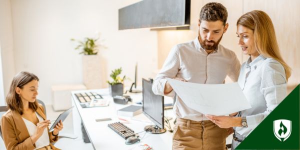 Three business people discuss a perceptual map in their office