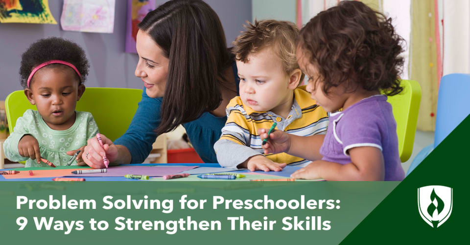 Photo of an adult interacting with preschoolers who are coloring and asking questions.