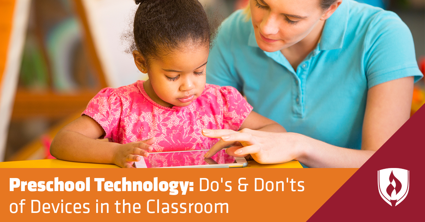 Teacher helping child with a tablet