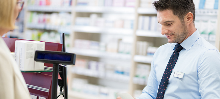 A pharmacy technician assisting a patient in a pharmacy setting