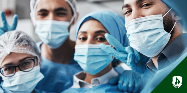 Four surgical technology students pose and smile at the camera in full scrub