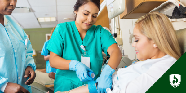 A clinical medical assistant tapes a patient