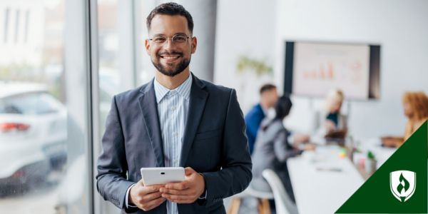 A legal secretary smiles, holding a tablet during a meeting