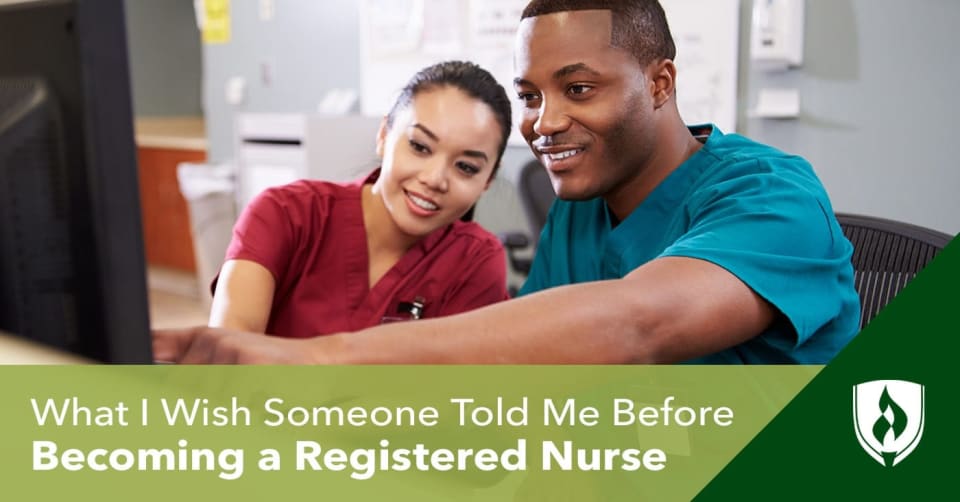 One nurse helping another with a computer at a nurse's station 