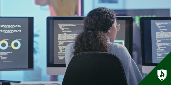 A web developer looks at three computer monitors