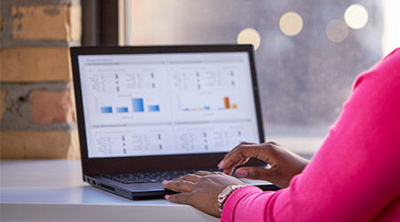 female working on graphs and charts on laptop