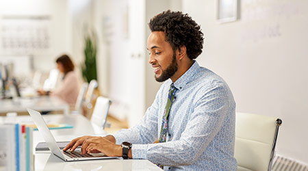 man in business attire working on laptop