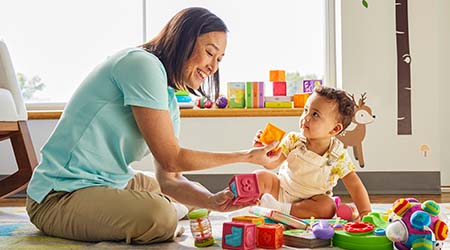 Teacher and small child playing with blocks