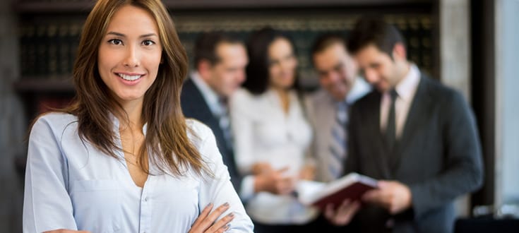 Photo of female paralegal standing confidently with arms crossed.