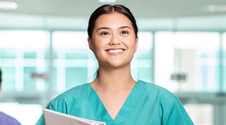 nurse in teal scrubs holding folder