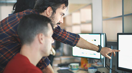 Two male IT Support professionals working at computer