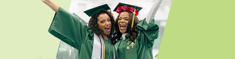 Two happy Rasmussen University graduates in caps and gowns at commencement